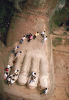 tourists standing on stone foot